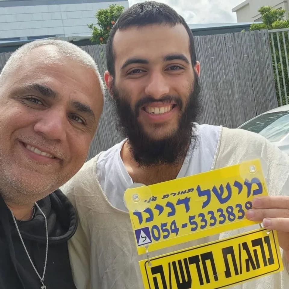 תלמיד מחזיק שלט נהג חדש לצד מישל דנינו