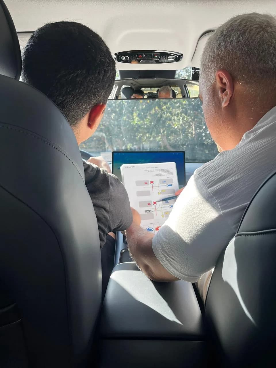 מישל דנינו מסביר לתלמיד תרגיל נהיגה בתוך רכב הלימוד